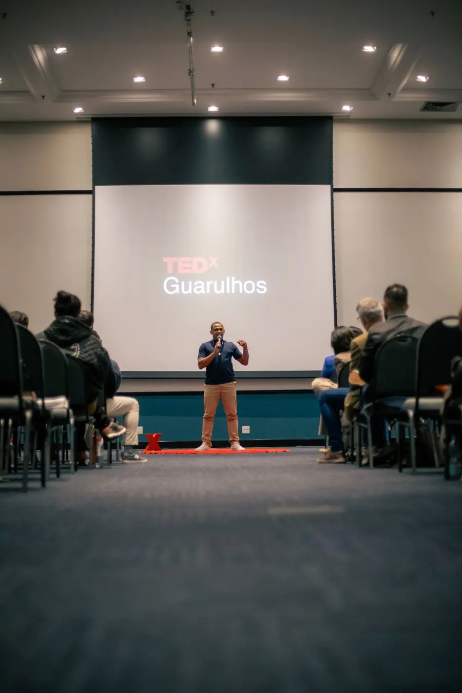 Rodolfo Pinheiro no palco do TEDxGuarulhos diante da plateia